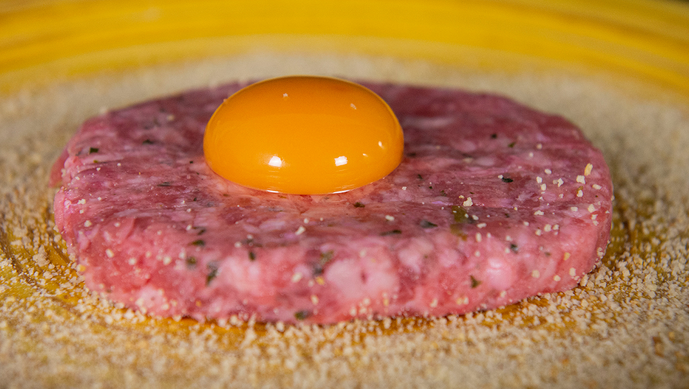 Huevo sobre una hamburguesa en una tabla